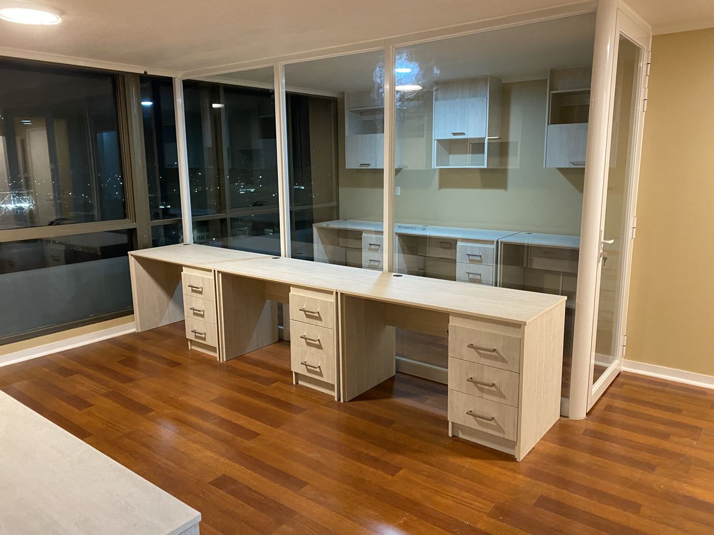 Oficina con escritorio corrido y cajoneras